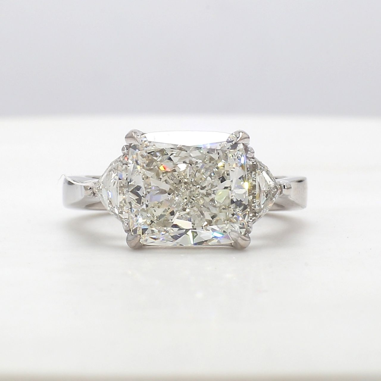 3-stone ring in platinum with prong set J/SI1 GIA certified cushion cut center and trilliant diamond sides.  D5.72ct.t.w.  (Center - 5.01ct.)  Size 6.25