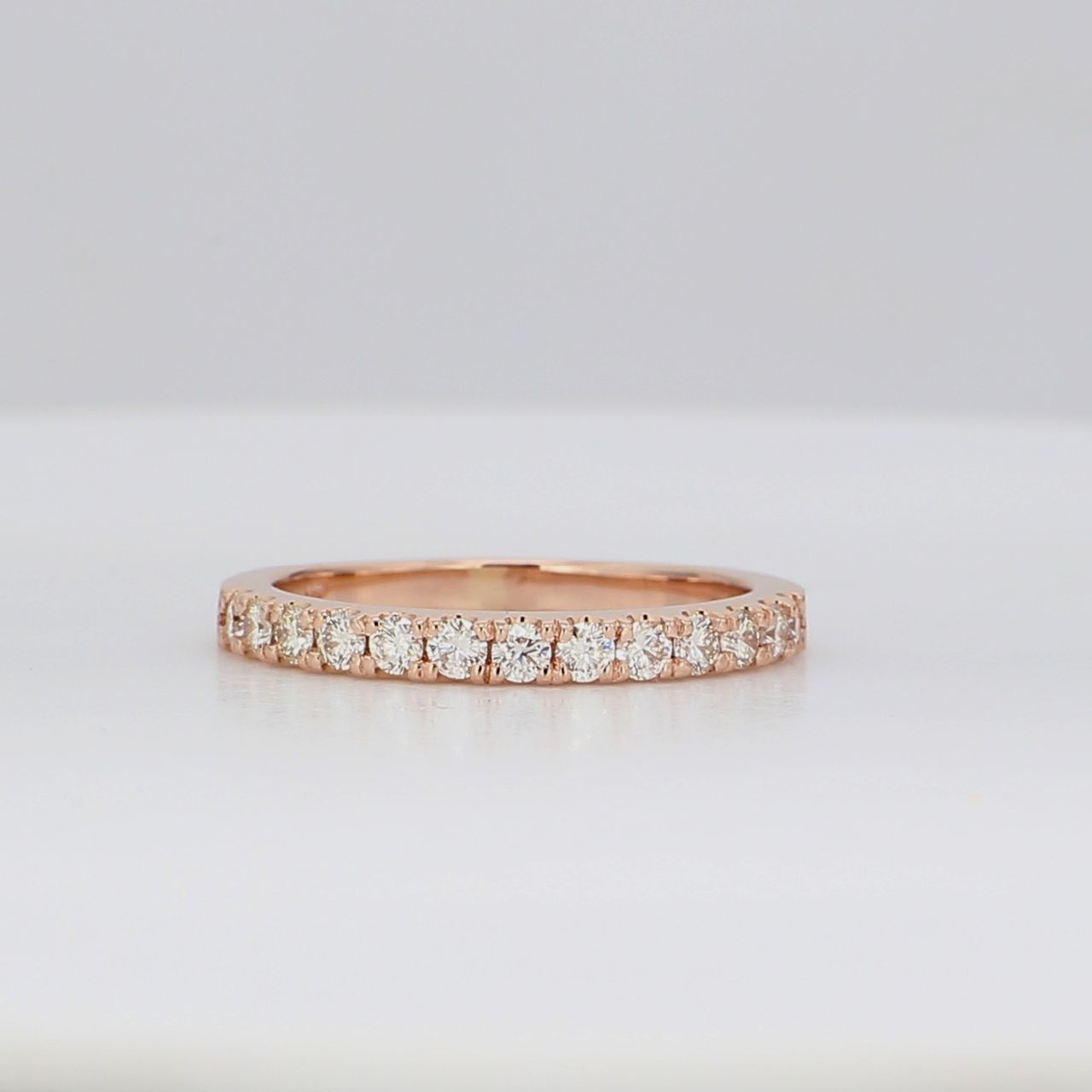 Band in 14K RG with half-way shared prong set round diamonds.  D0.37ct.t.w.  Size 5