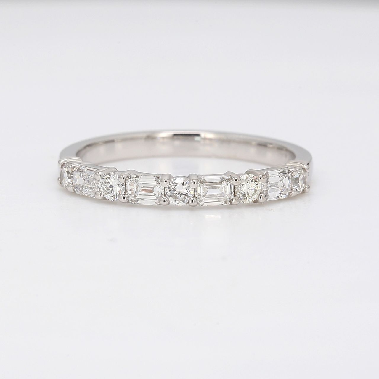 Band in platinum with alternating prong set round and emerald cut diamonds.  D0.60ct.t.w.