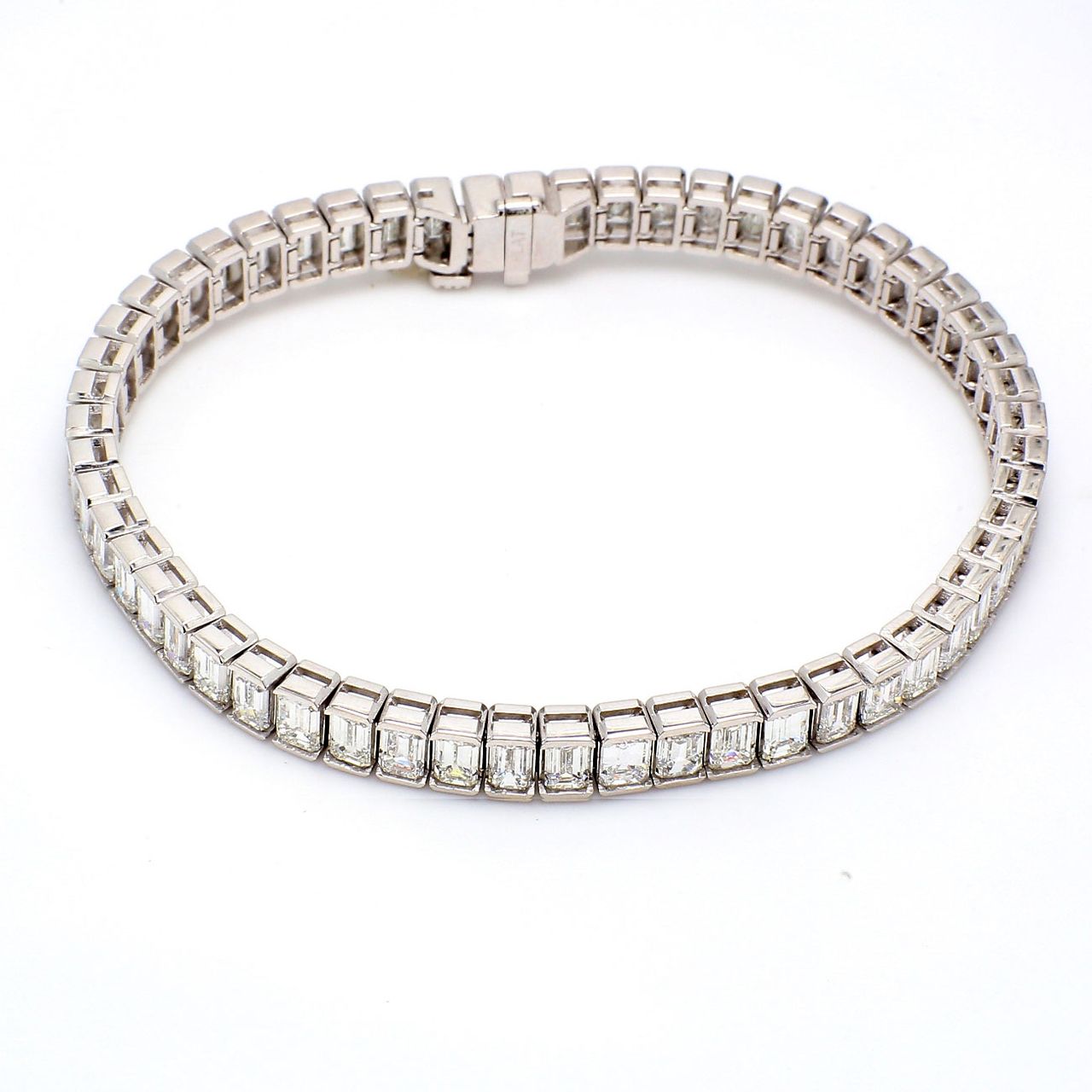 7' Tennis bracelet in platinum with half bezel set (55) emerald cut diamonds.  D13.45ct.t.w.
