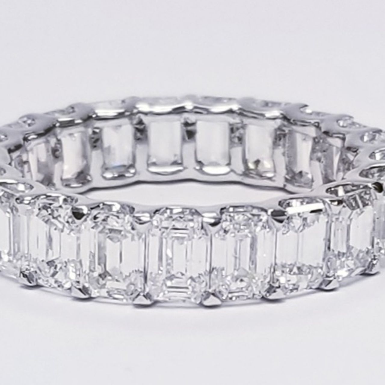 Eternity band in platinum with shared U-prong set (23) emerald cut diamonds.  D5.74ct.t.w.  Size 6