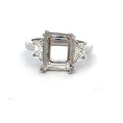 3-stone semi mount in platinum with prong set trapezoid diamond side stones.  D0.84ct.t.w.  Size 6.75
