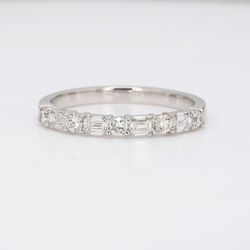 Band in platinum with alternating prong set round and emerald cut diamonds.  D0.60ct.t.w.