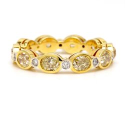 Eternity band in 18K YG with alternating bezel set rounds & fancy yellow oval diamonds.  D3.29ct.t.w.  Fancy Yellow 3.14ct.t.w.  Size 7