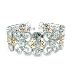 7.5' Designer bracelet in 18K two-tone with French pave set rounds around bezel set cushion cut diamonds.  D10.81ct.t.w.