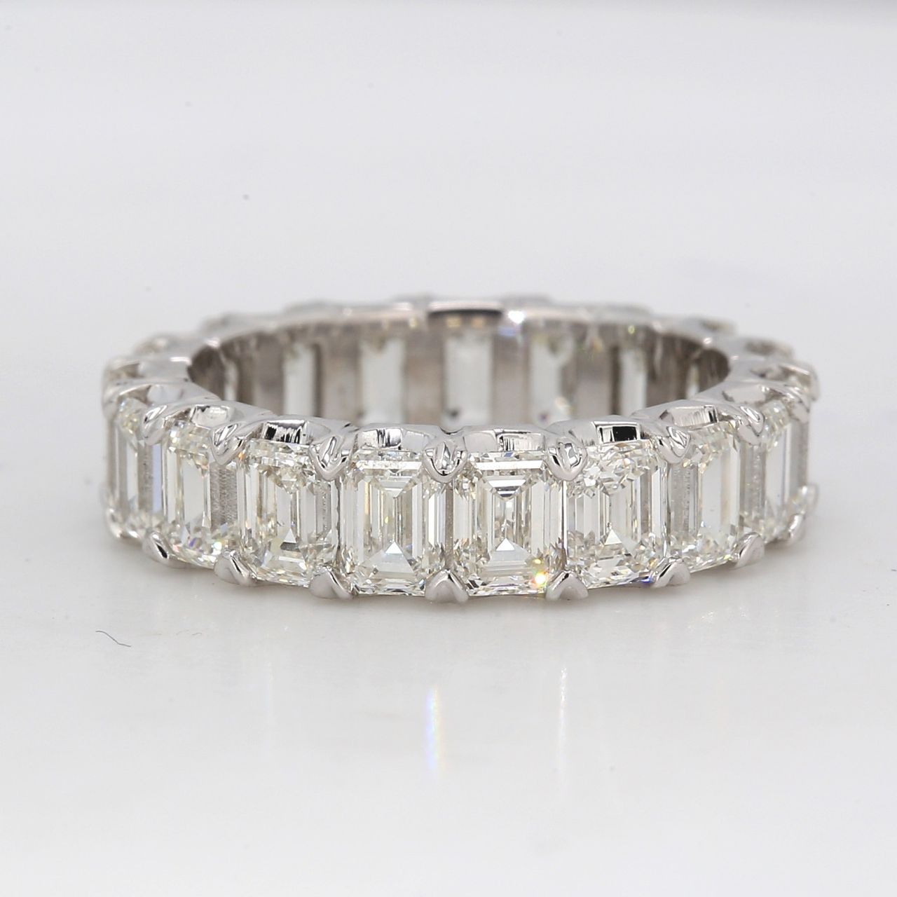 Eternity band in platinum with shared V-prong set single basket emerald cut diamonds.  D5.75ct.t.w.  Size 5.25