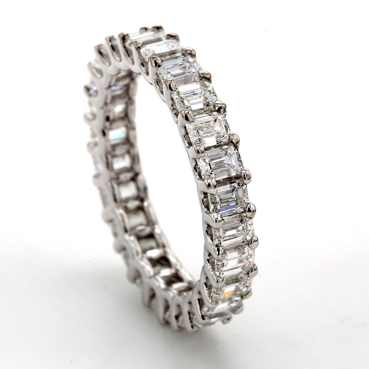 Eternity band in platinum with shared U-prong set emerald cut diamonds.  D5.89ct.t.w.